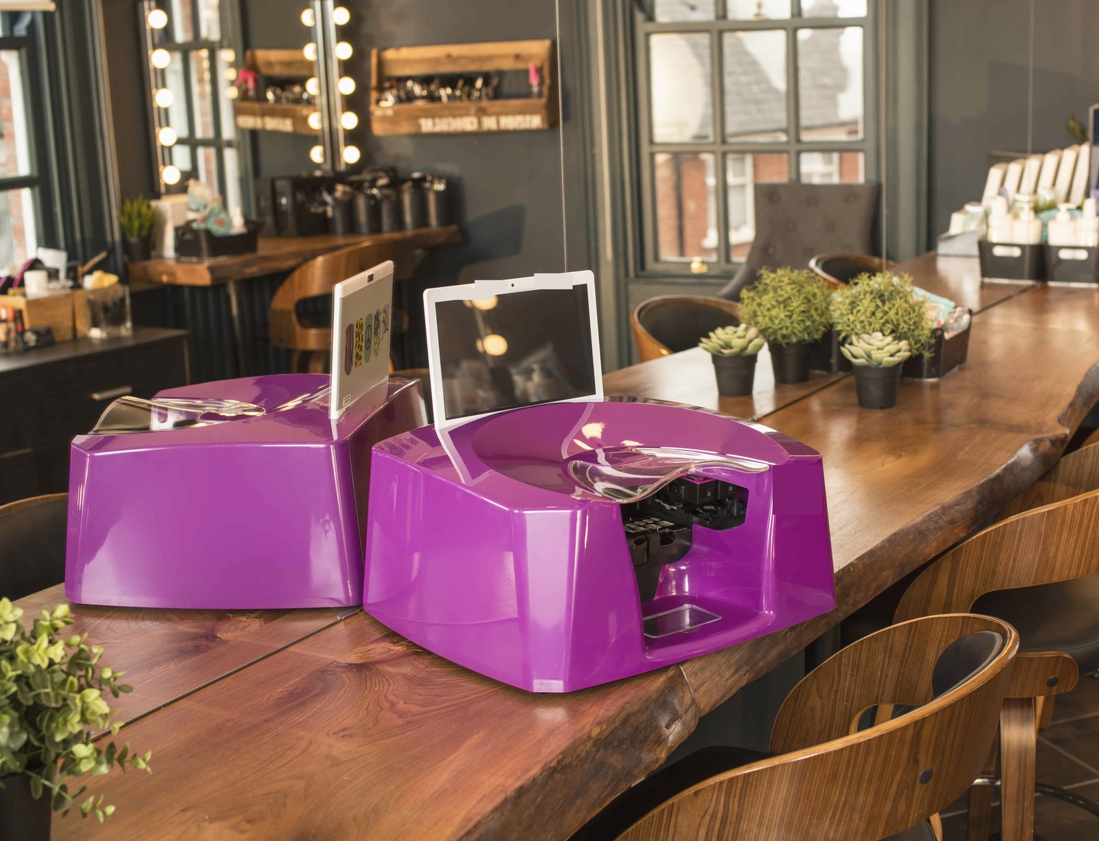 Two countertop nail art printers on a café table